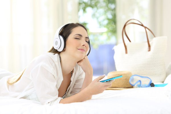 kobieta sluchajaca muzyki relaksujaca w pokoju