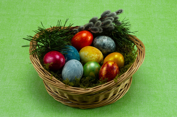 wielkanoc kolorowe malowane jajka w wiklinowym