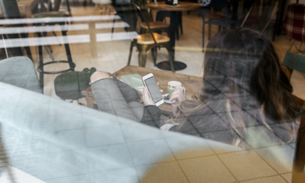 kobieta za pomoca smartfona w kawiarni